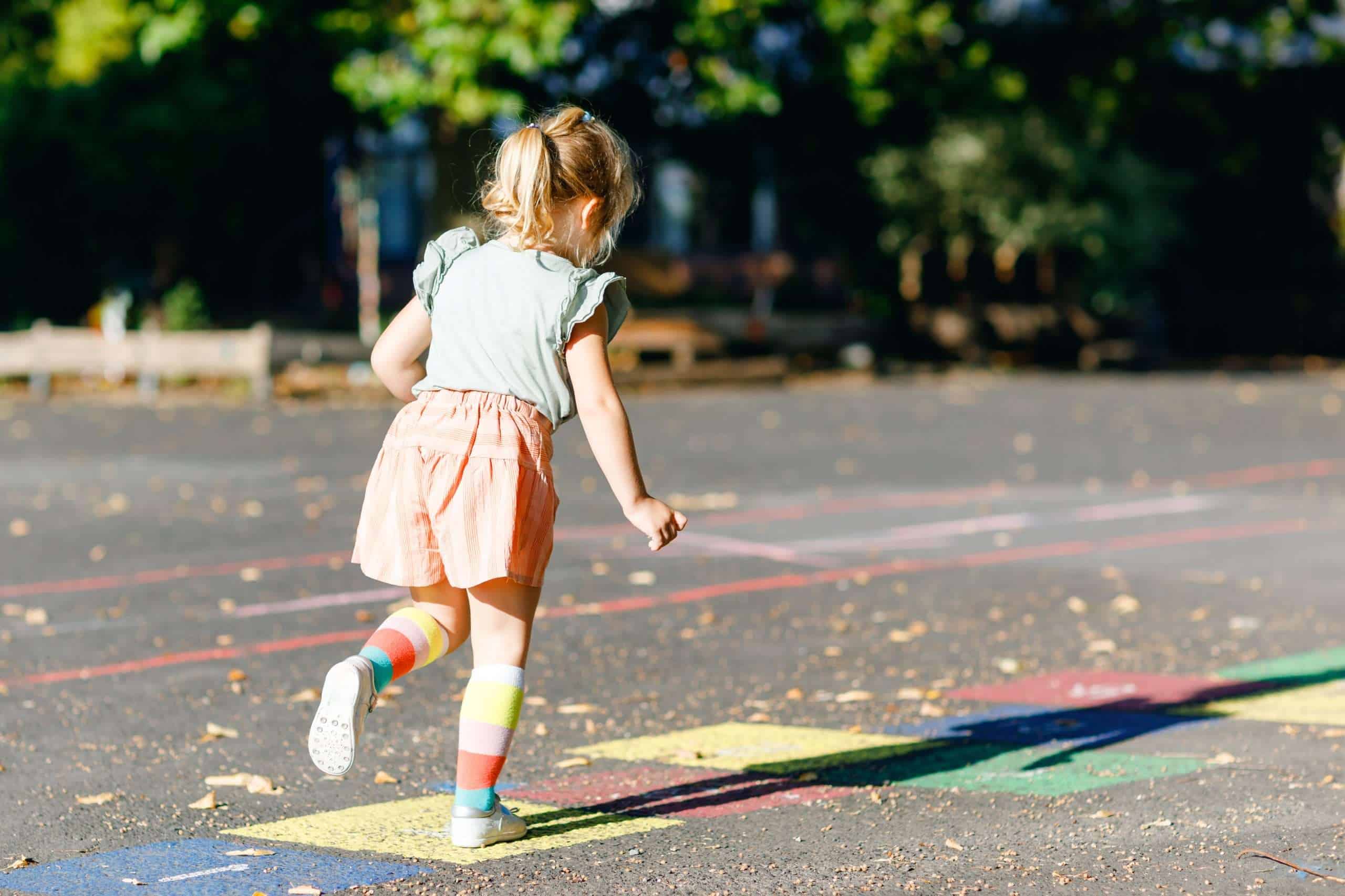 girl playing a summer activity called hop scotch 