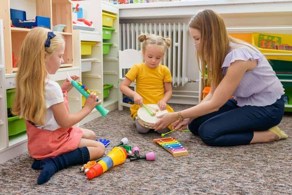 Two Toddlers Showing A Parent Or Therapist Their Toys