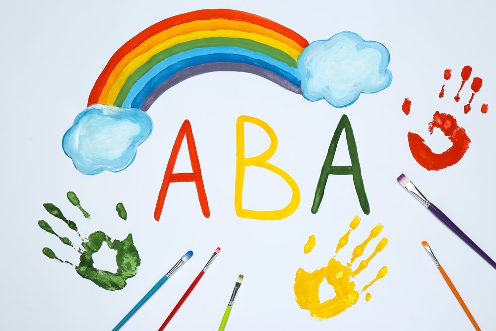 “ABA” Drawn With Paint Below A Rainbow