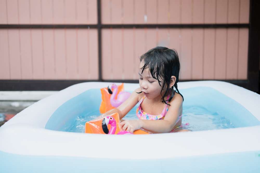 Young girl playing in a kiddie pool