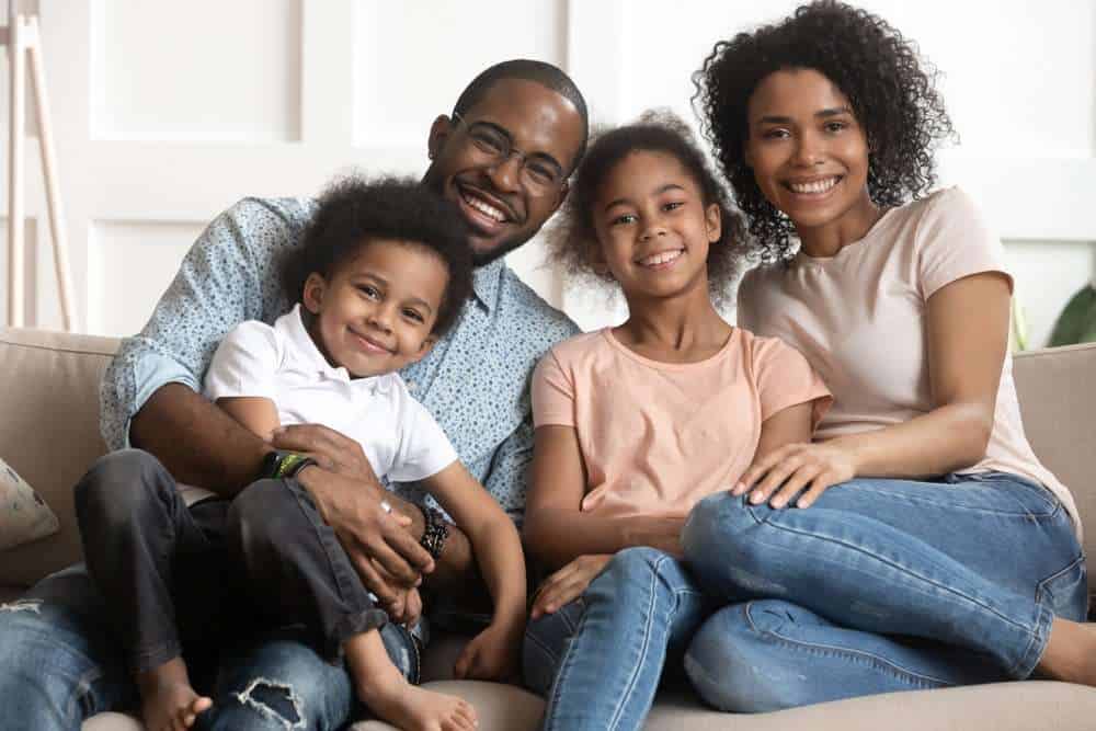  Married Couple On A Couch With Their Two Young Children