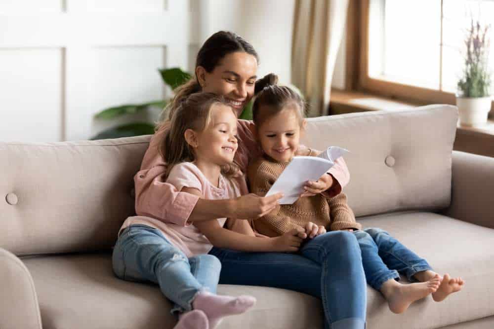 Mother Reading On The Couch With Her Two Kids