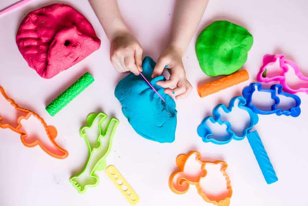 Young Child With Autism Playing With Colorful Playdough And Tools