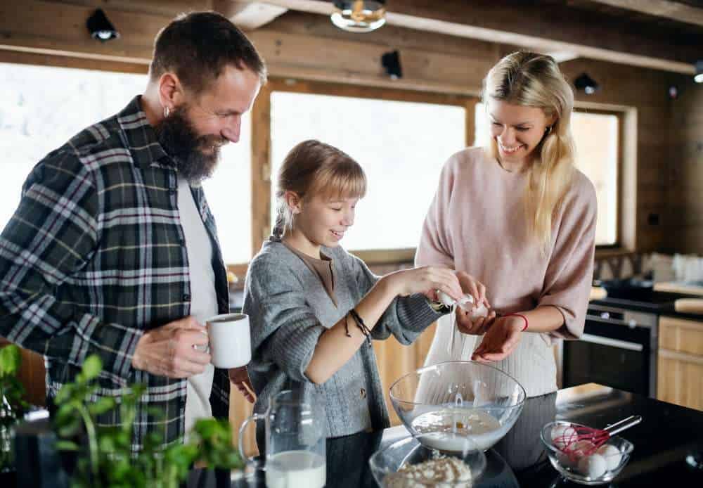 Mom and Dad Helping Their Daughter With Autism Bake In the Kitchen