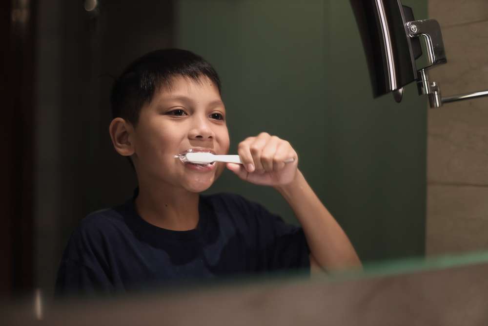Teen brushing their teeth