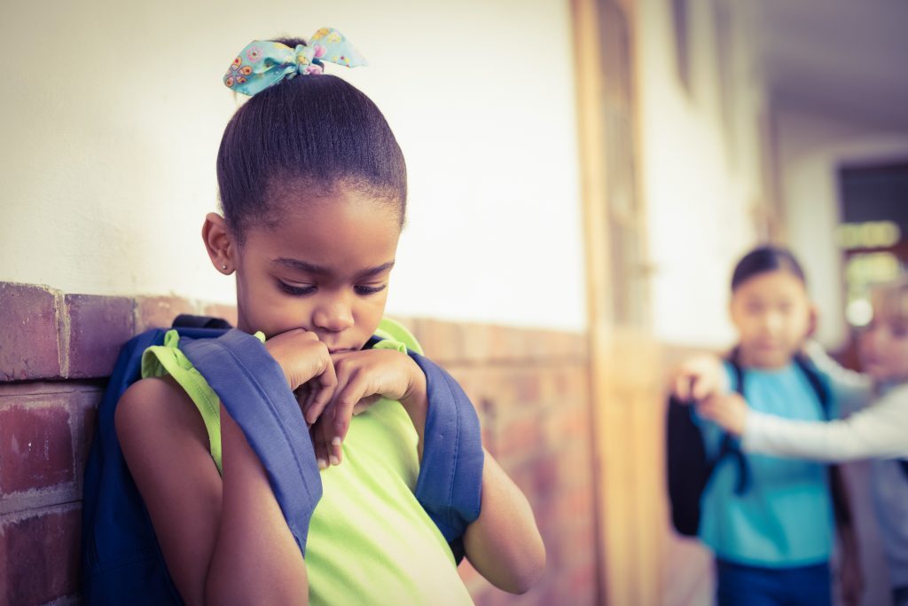 Kids Laughing At Young Girl At School Who Has Trouble Socializing