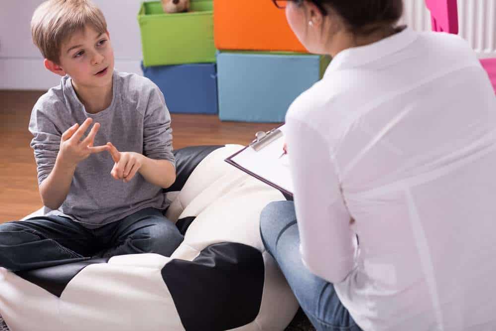 Young Boy Answering ABA Therapist's Questions For Chaining Exercise