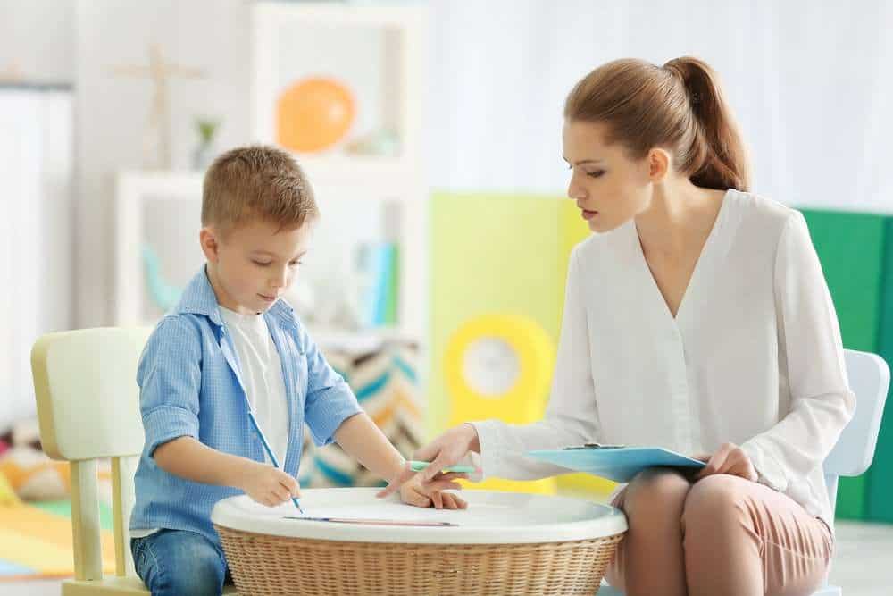 BCBA Therapist Helping Boy With Autism On Therapy Activity